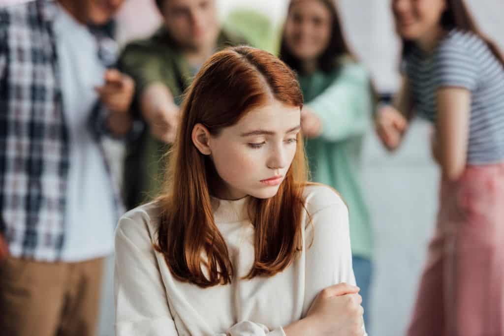 cropped view of group of teenagers bullying girl