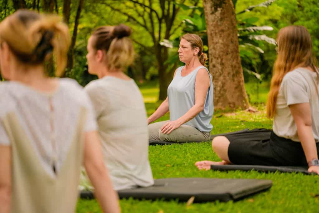 group of women doing meditation outdoors