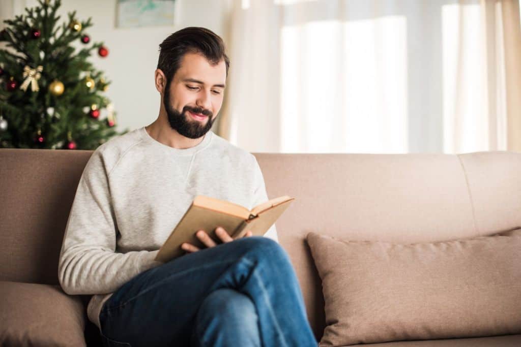man reading a book at home