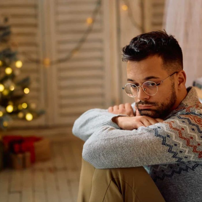 Pensive man feeling sad while being alone at home for Christmas